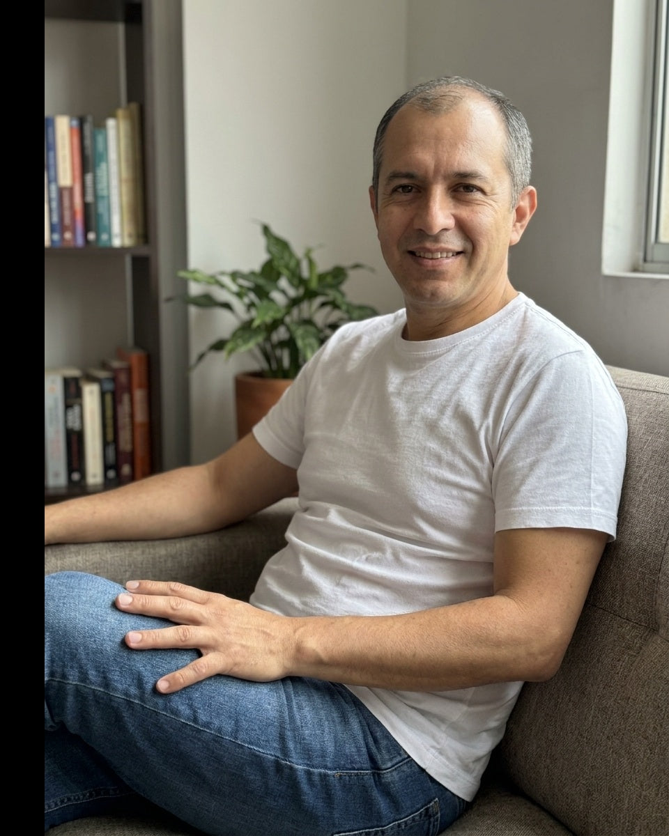 Hombre de 47 años sonriendo en el sofá de su sala